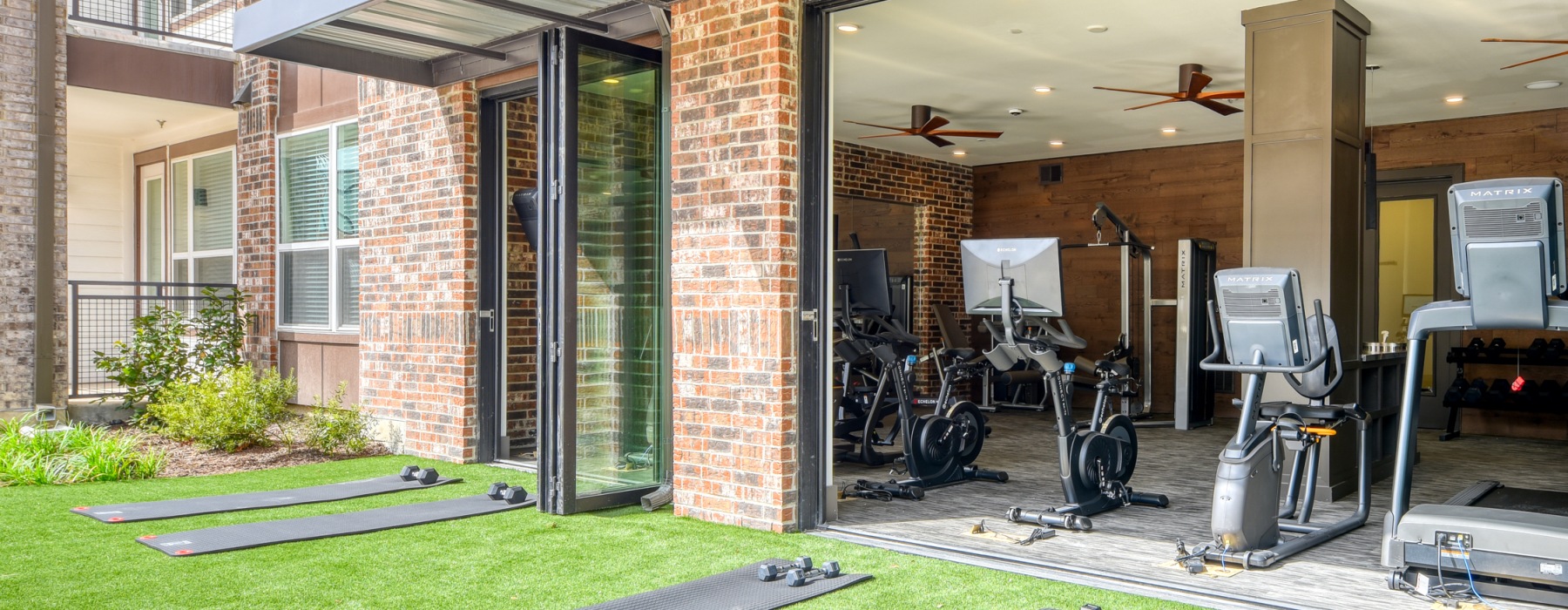 Fitness center with exercise equipment and outside access at Citadel Urban's upscale apartments in San Antonio