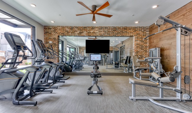 Fitness center with exercise equipment and outside access at Citadel Urban's upscale apartments in San Antonio